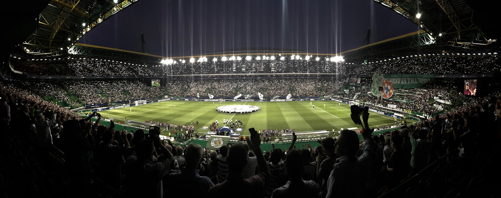 Nézők követnek egy futballmérkőzést a stadion lelátójáról.